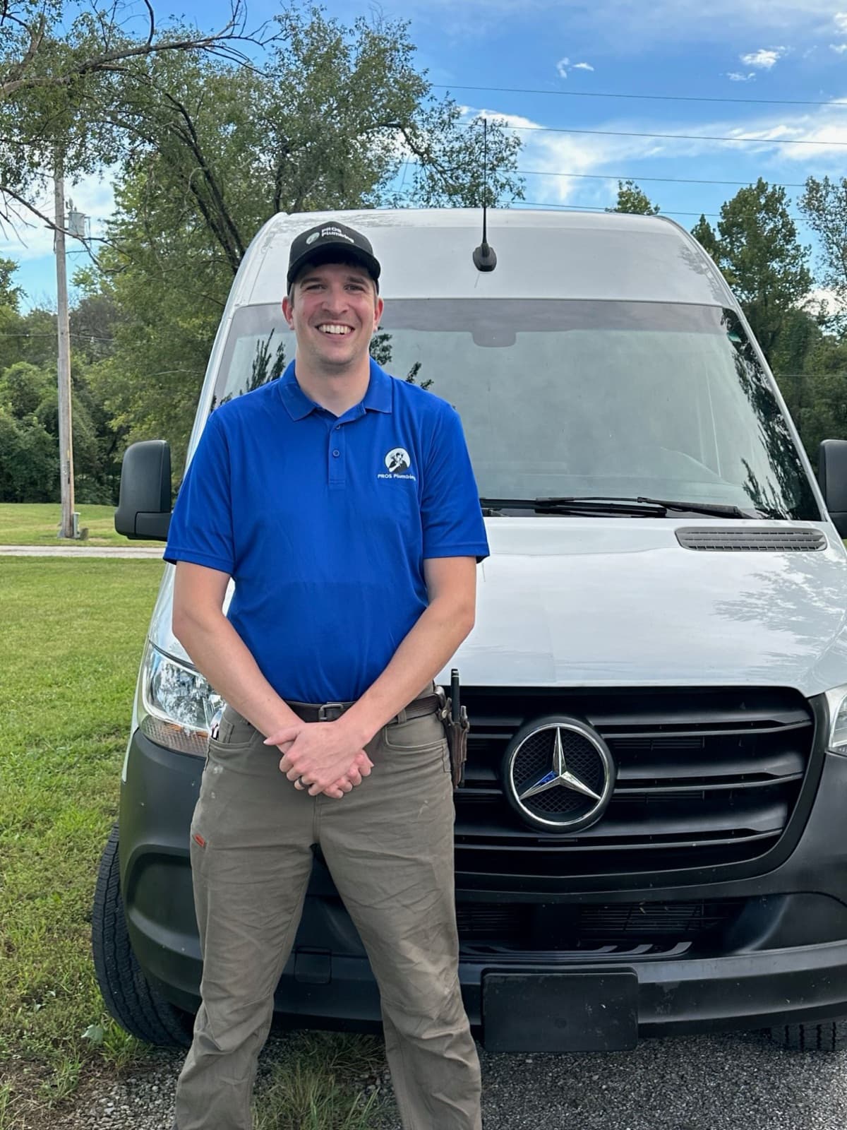 PROS Plumbing plumber in uniform in front of the service van